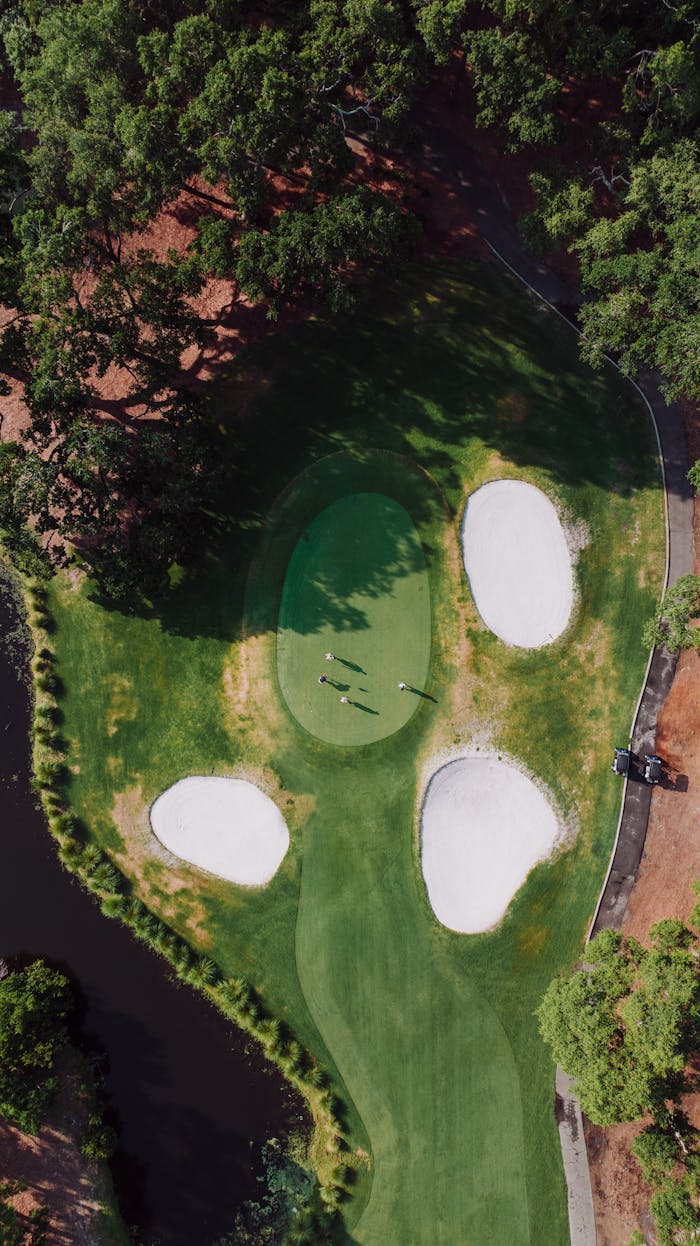 Aerial shot of a green golf course with sand bunkers and carts at Hilton Head Island.